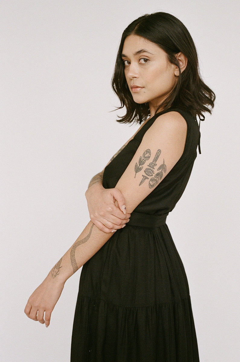 Woman in a Tiered Maxi Dress - Black showing off tattoos on her arms.
