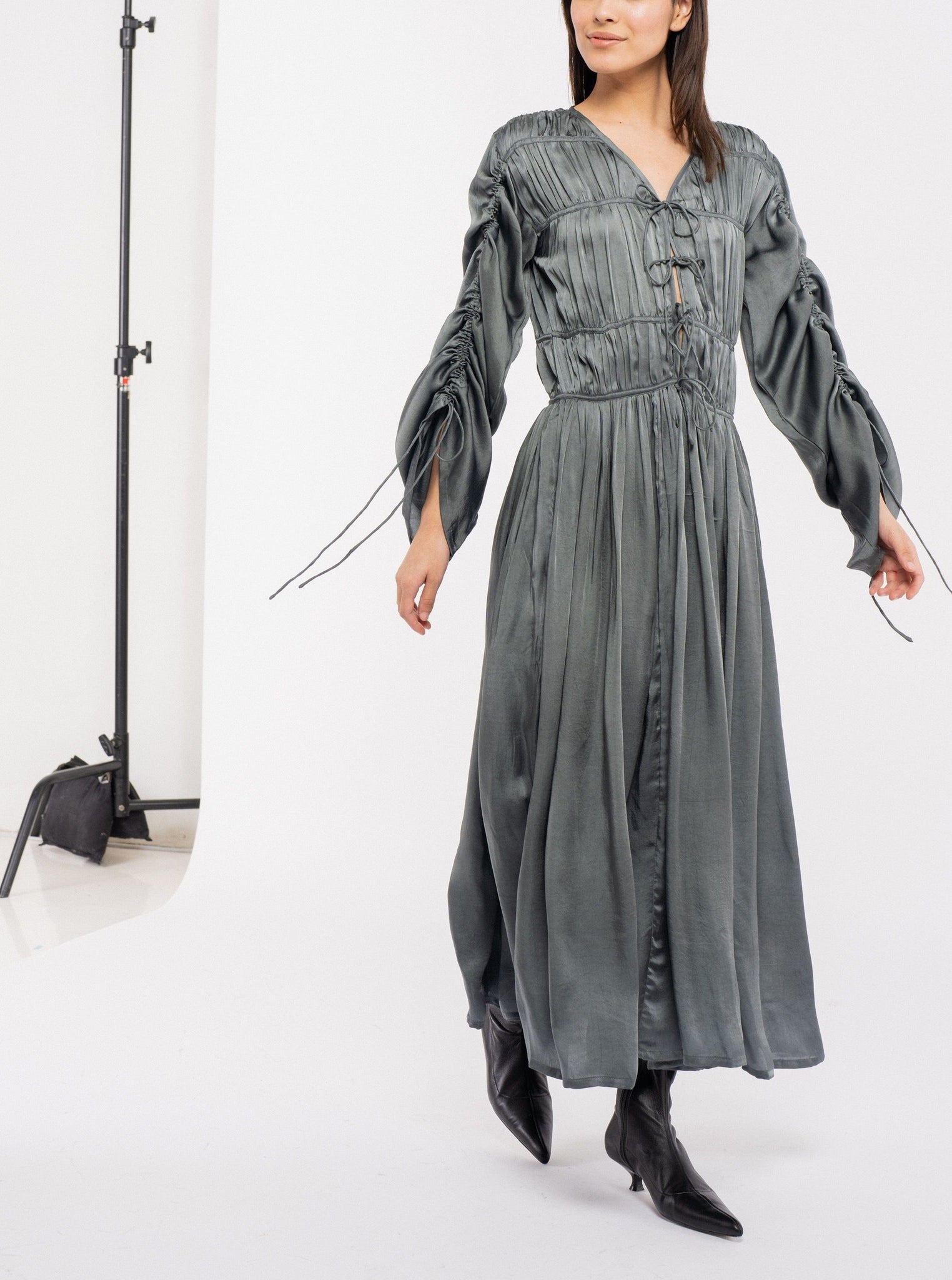 The model is wearing an Iris Dress - Slate with adjustable sleeves.