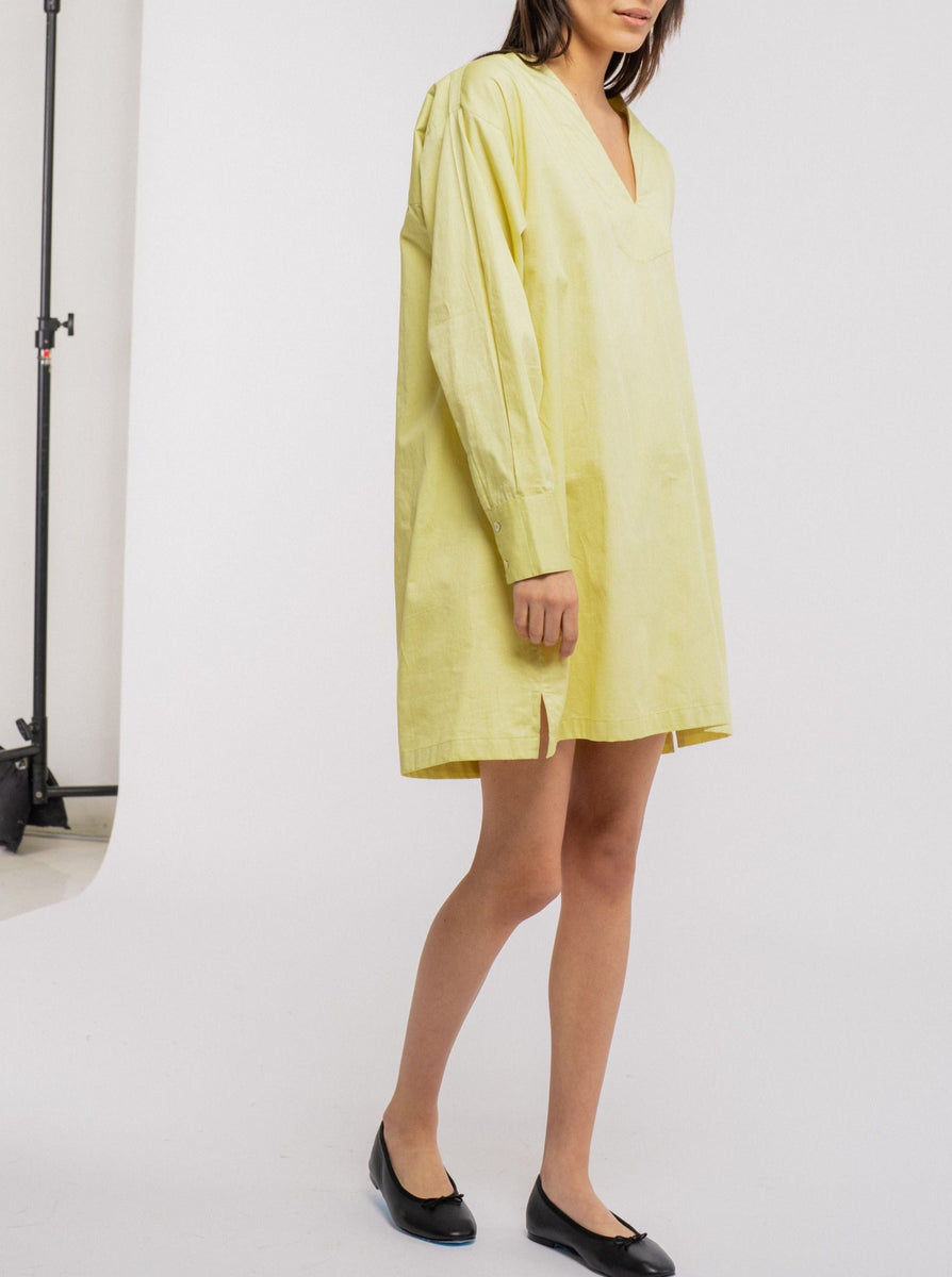 The model is wearing a comfortable yellow v-neck Modern Tunic Dress - Celery Green made of organic cotton.