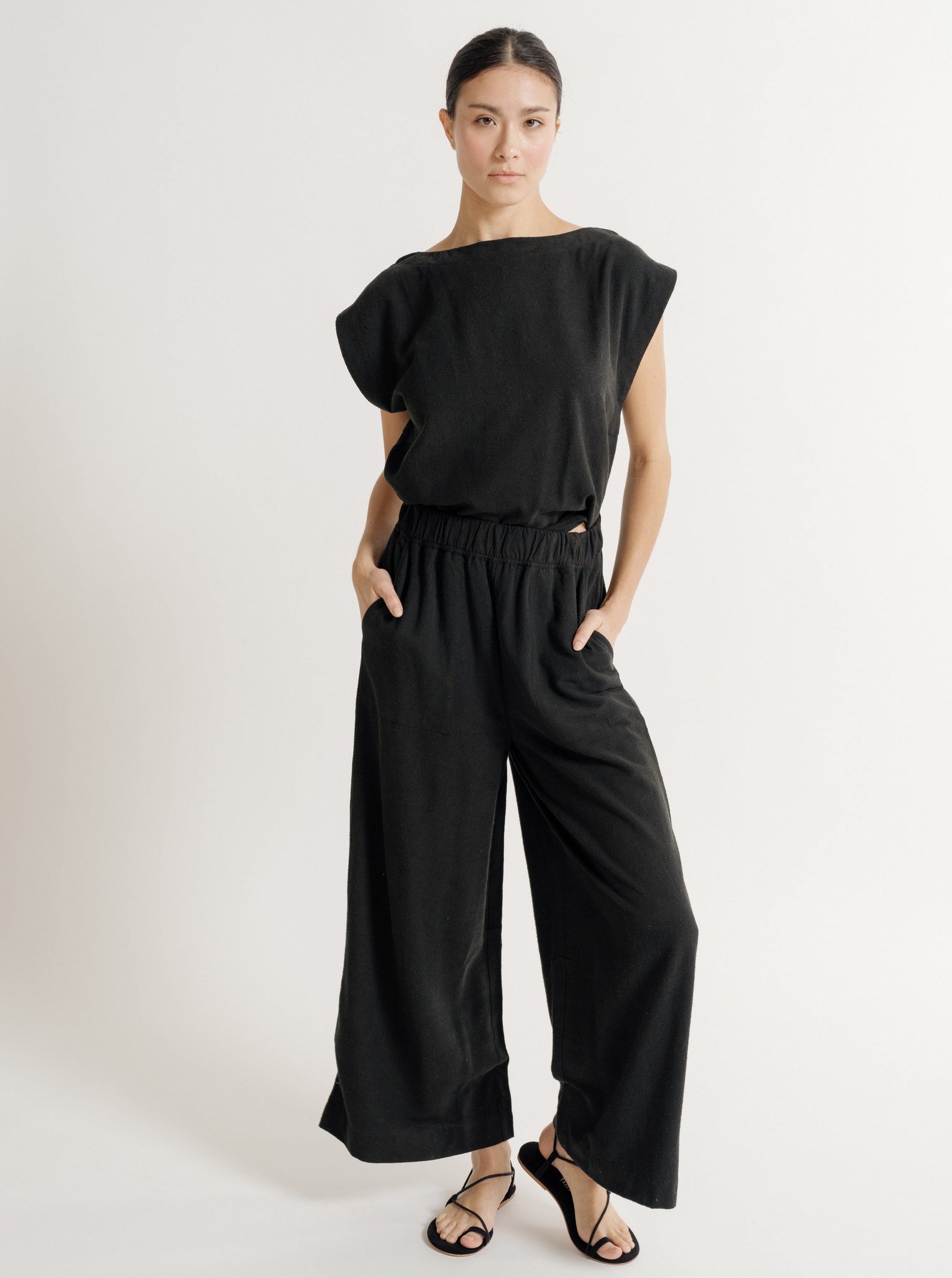 A sustainable woman wearing the Everyday Pant - Black Silk Noil - Pre-order and sandals.
