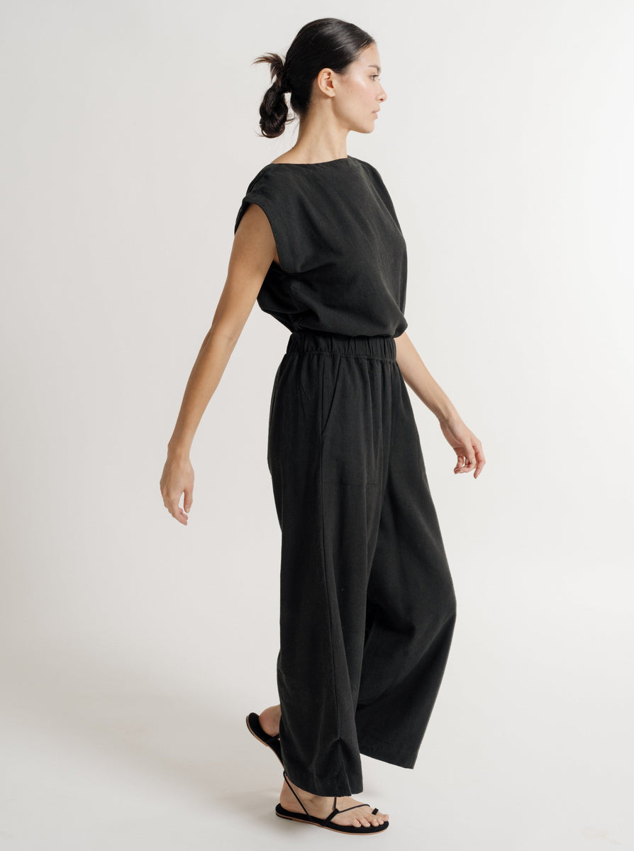 An eco-conscious woman wearing the Everyday Pant - Black Silk Noil - Pre-order and sandals.