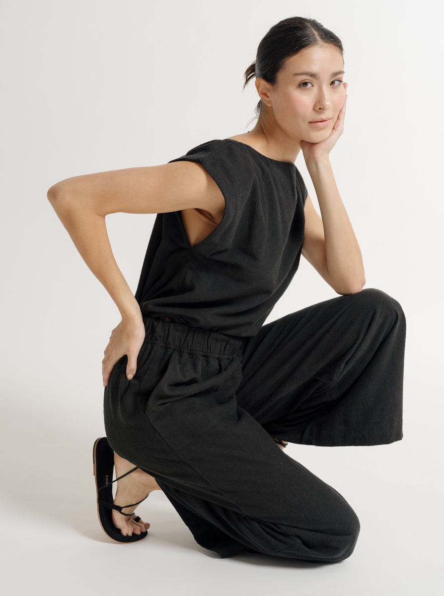 A sustainable Everyday Pant - Black Silk Noil - Pre-order crouching on the floor.