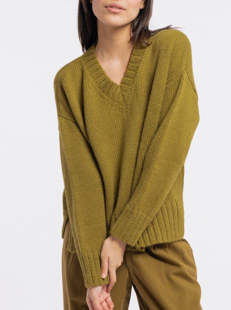 The model is wearing a cozy Billy Sweater - Yucca Green.