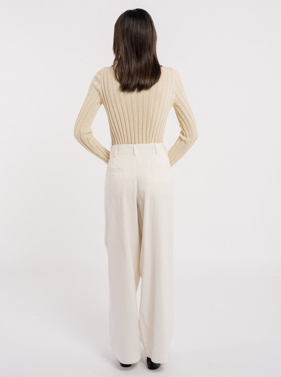 The back view of a woman wearing the Soa Ribbed Turtleneck - Vanilla made of baby alpaca.