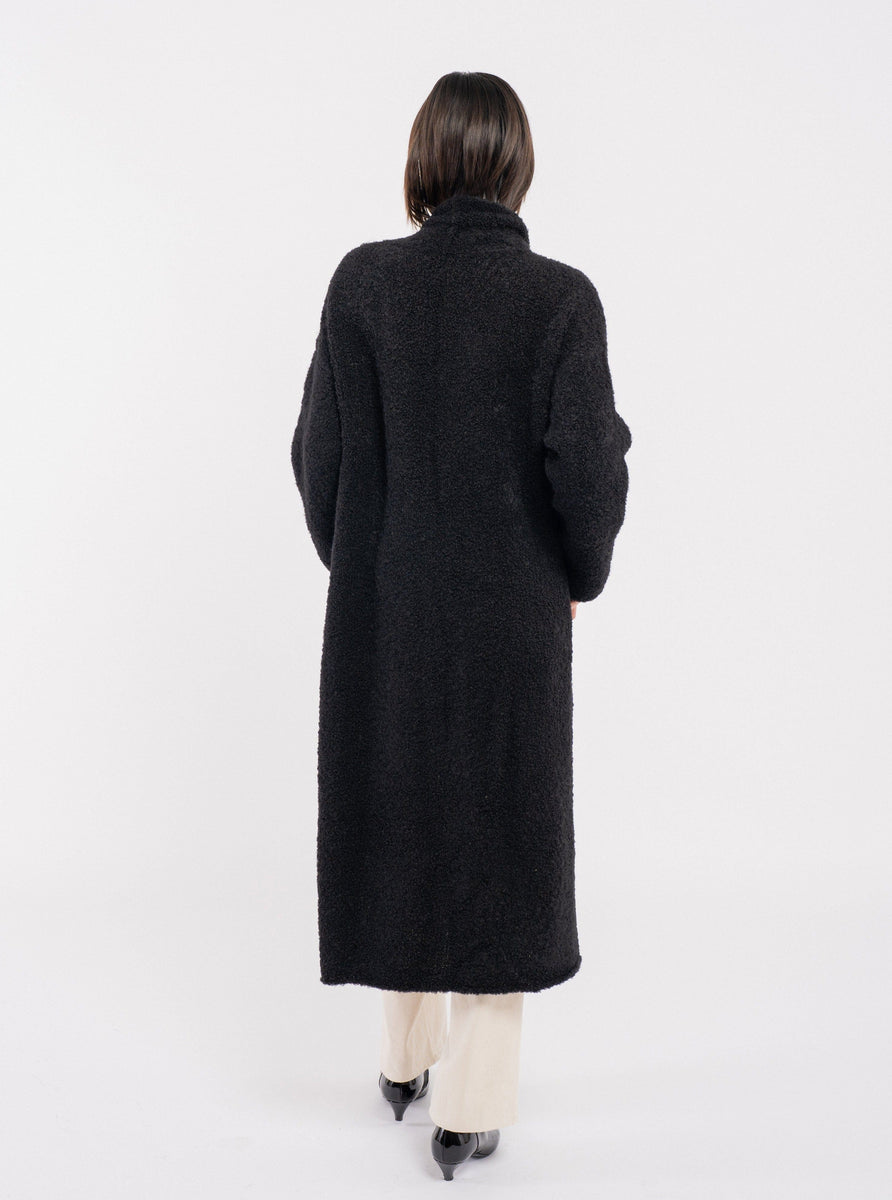 The back view of a woman wearing the Heirloom Sweater Coat - Black.