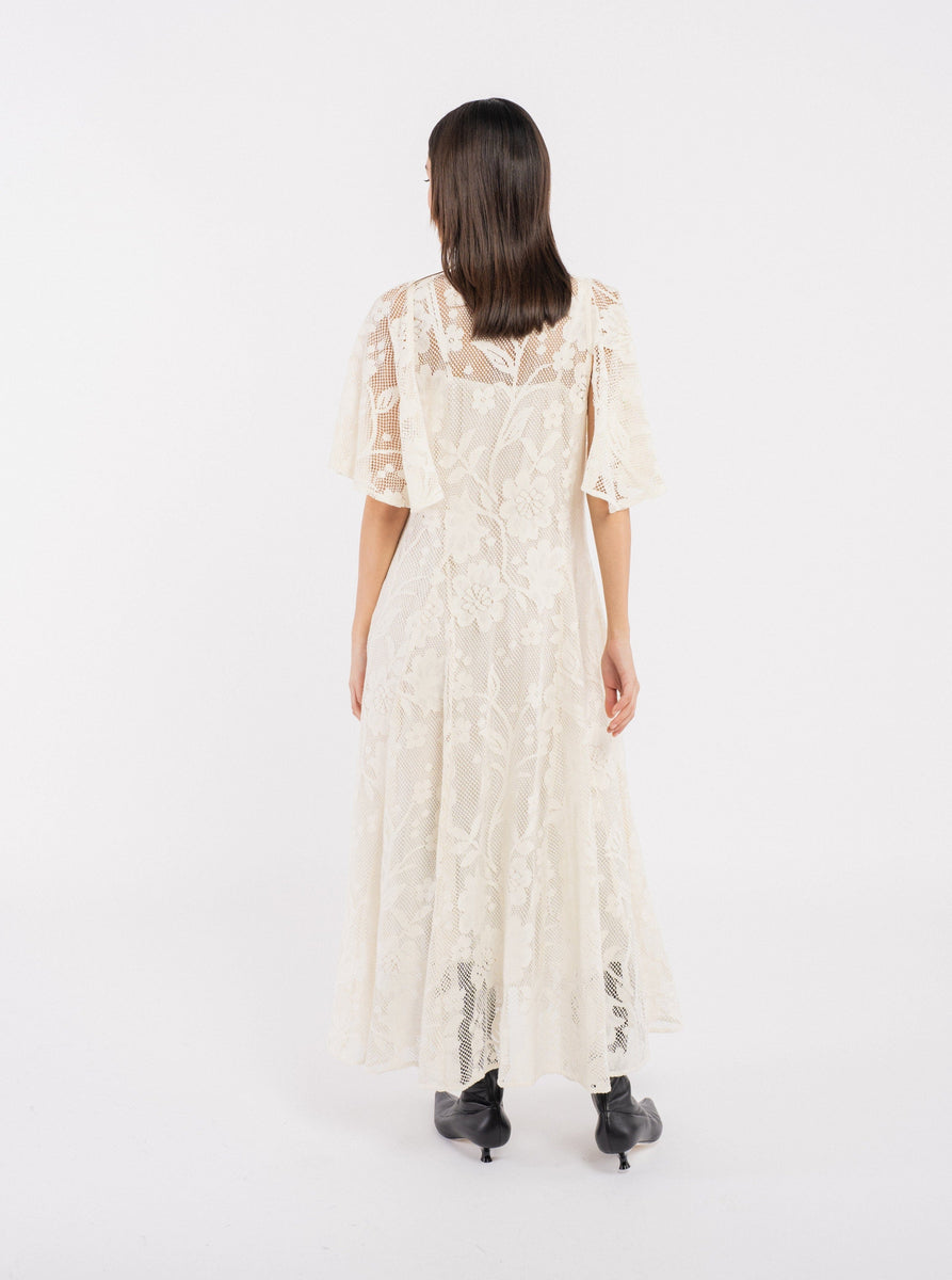 The back view of a woman wearing an Ailes Dress - Ivory - Sample in like-new condition.