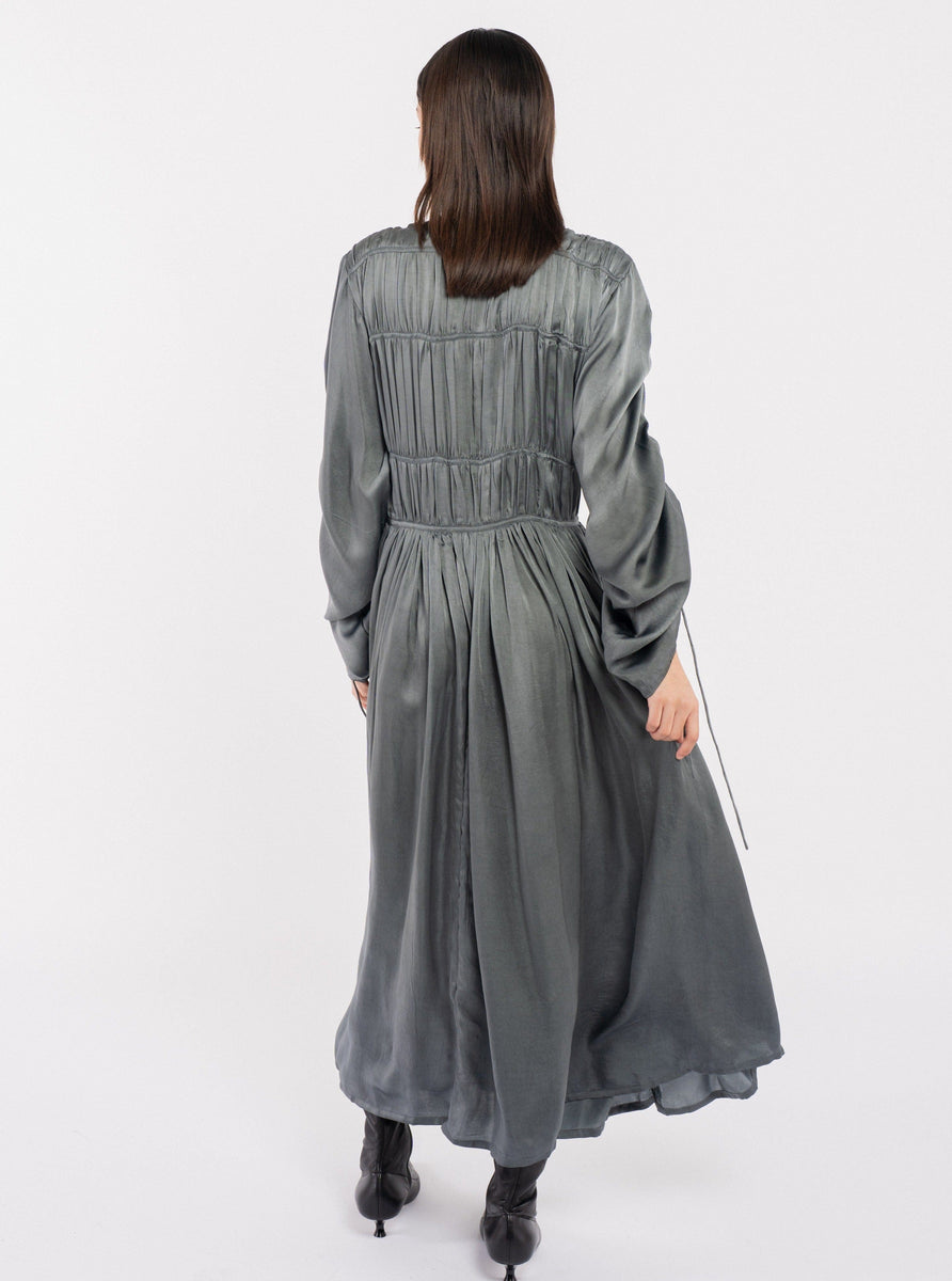 The back view of a woman wearing an Iris Dress - Slate with adjustable sleeves.