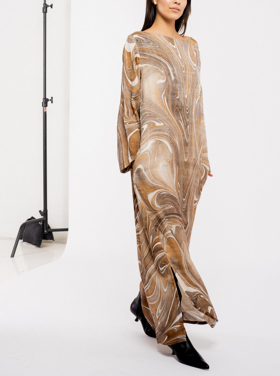The model is wearing a Sparrow Dress - Hand Marble in a brown and beige marbled pattern.