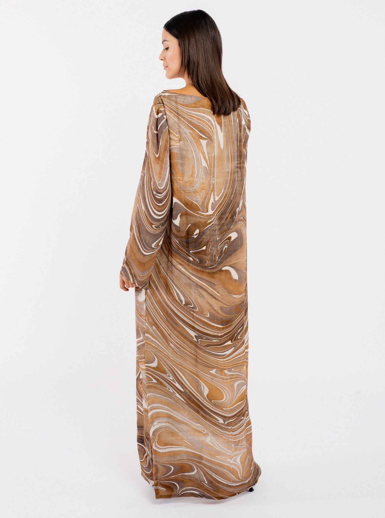 The back view of a woman wearing a long fluid maxi length Sparrow Dress - Hand Marble.