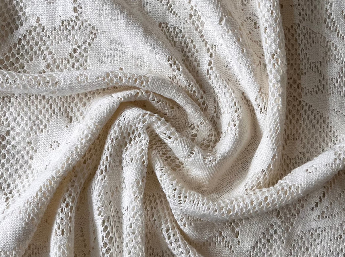 A close up of the Ailes Dress - Bone in white mesh lace fabric.