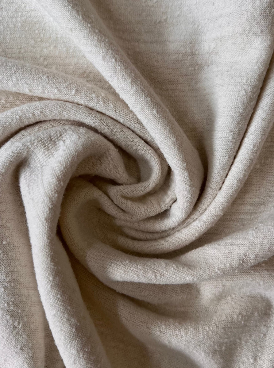 A sustainable close up of a beige silk Scoop Neck Tee - Ivory fabric.