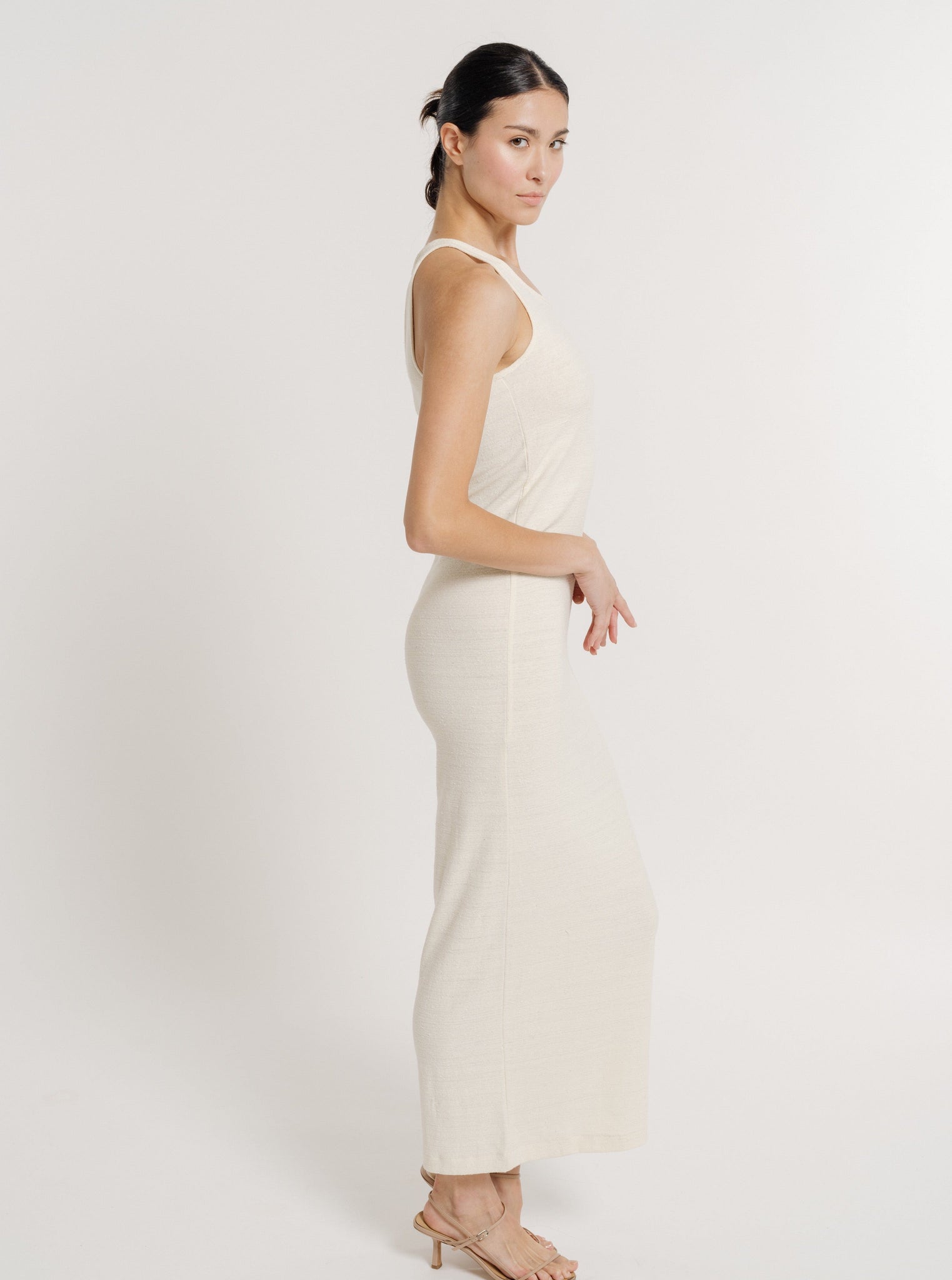 The model is wearing a sustainable Jersey Knit Tank Dress - Ivory Silk Noil - Pre-order, showcasing individuality.