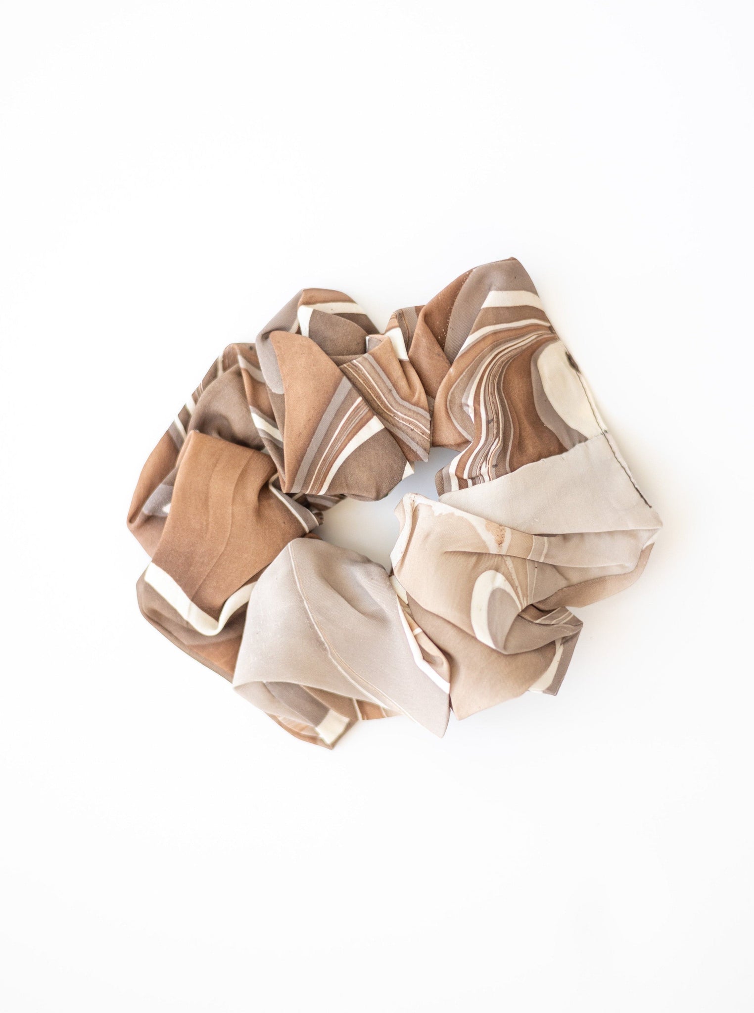 A brown and white Large Scrunchy - Hand Marble made from remnant fabrics on a white surface.