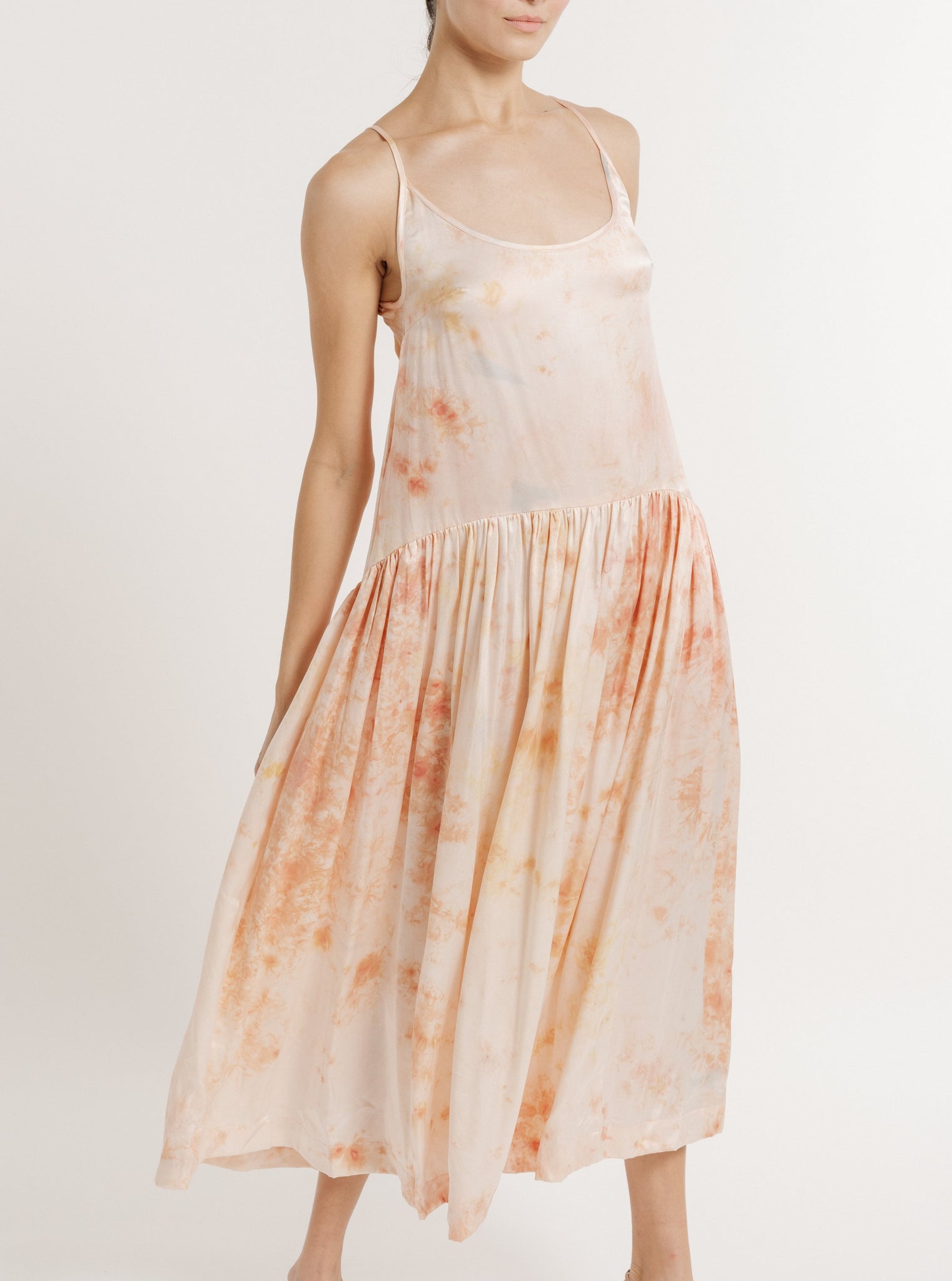 A woman in a white and orange Silk Midi Slip Dress - Botanical Ice Dye stands against a light background.