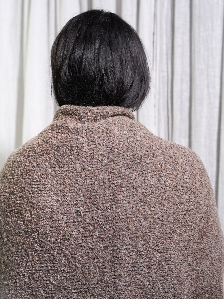 The back of a woman wearing a cozy Remy Blanket.