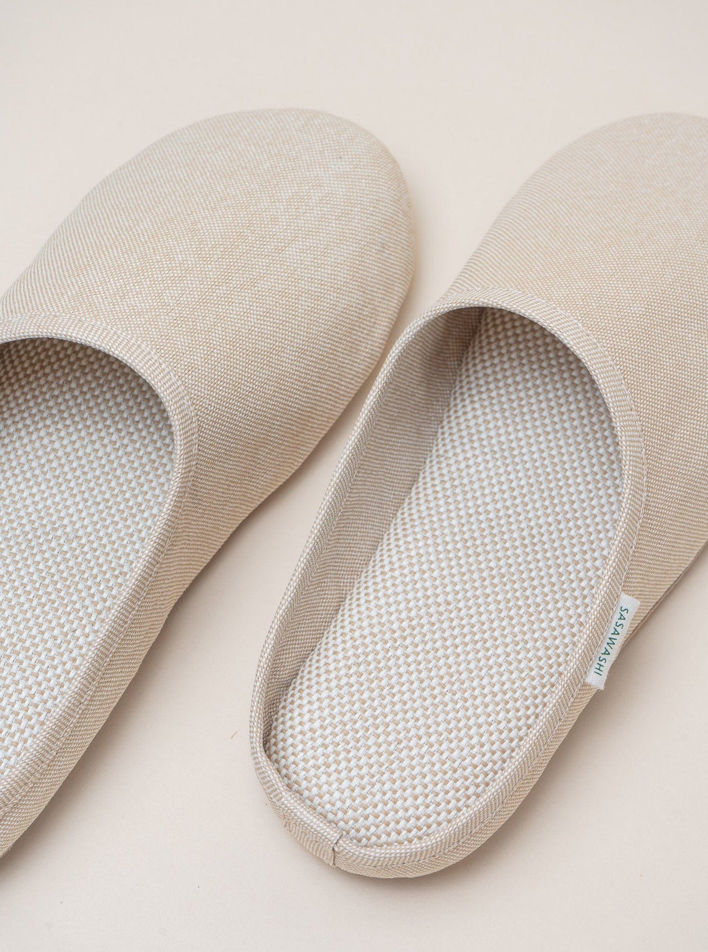 A pair of breathable beige Sasawashi Room Shoes made with Sasawashi fabric on a white surface.