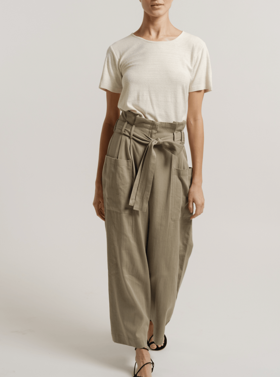 The model is wearing a white t-shirt and khaki Paper Bag Pant - Putty - Pre-order made of cotton sateen.