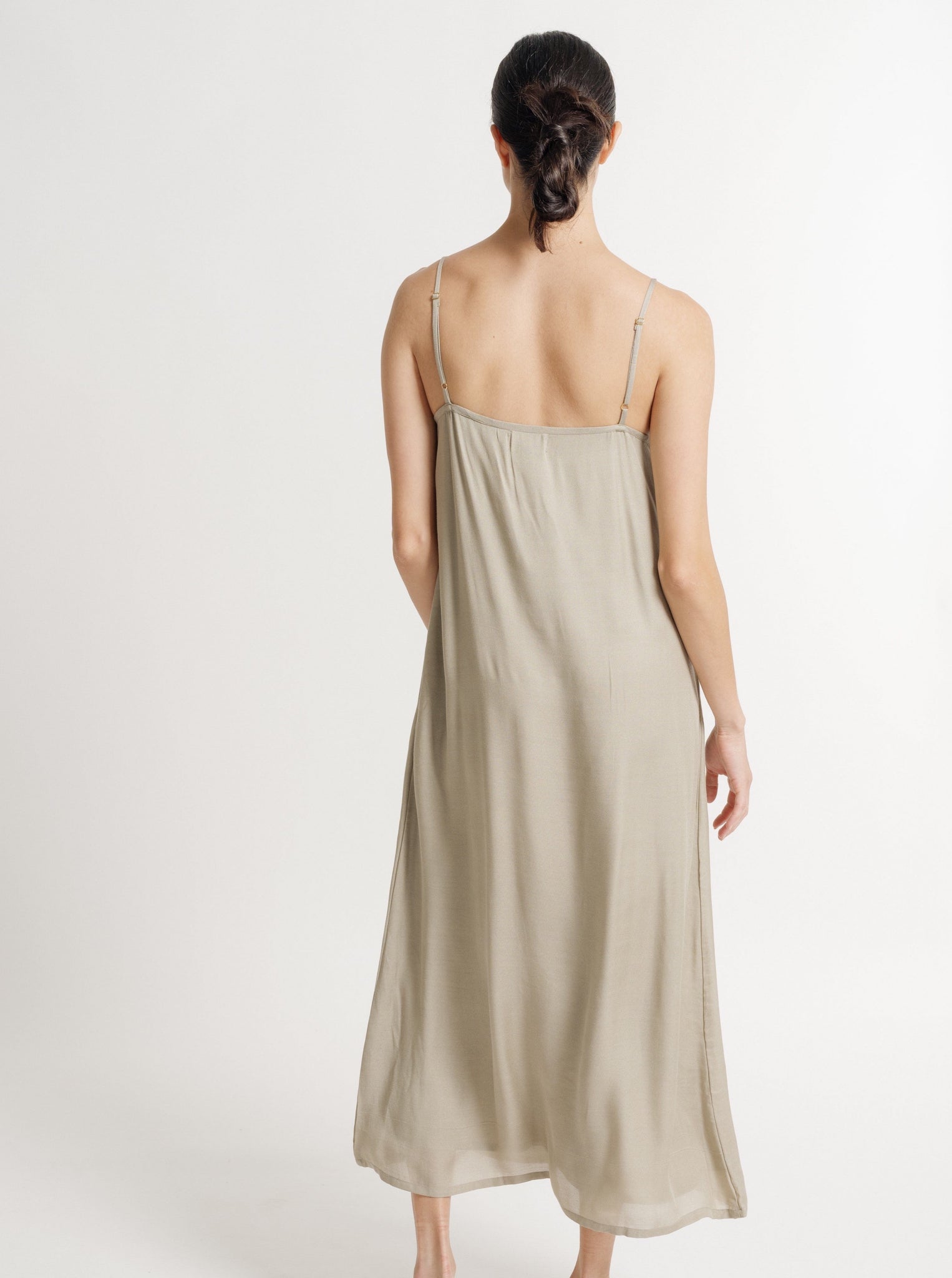 The back view of a woman wearing a 90's Maxi Slip Dress - Putty - Pre-order in sage Bemberg Cupro Crepe.