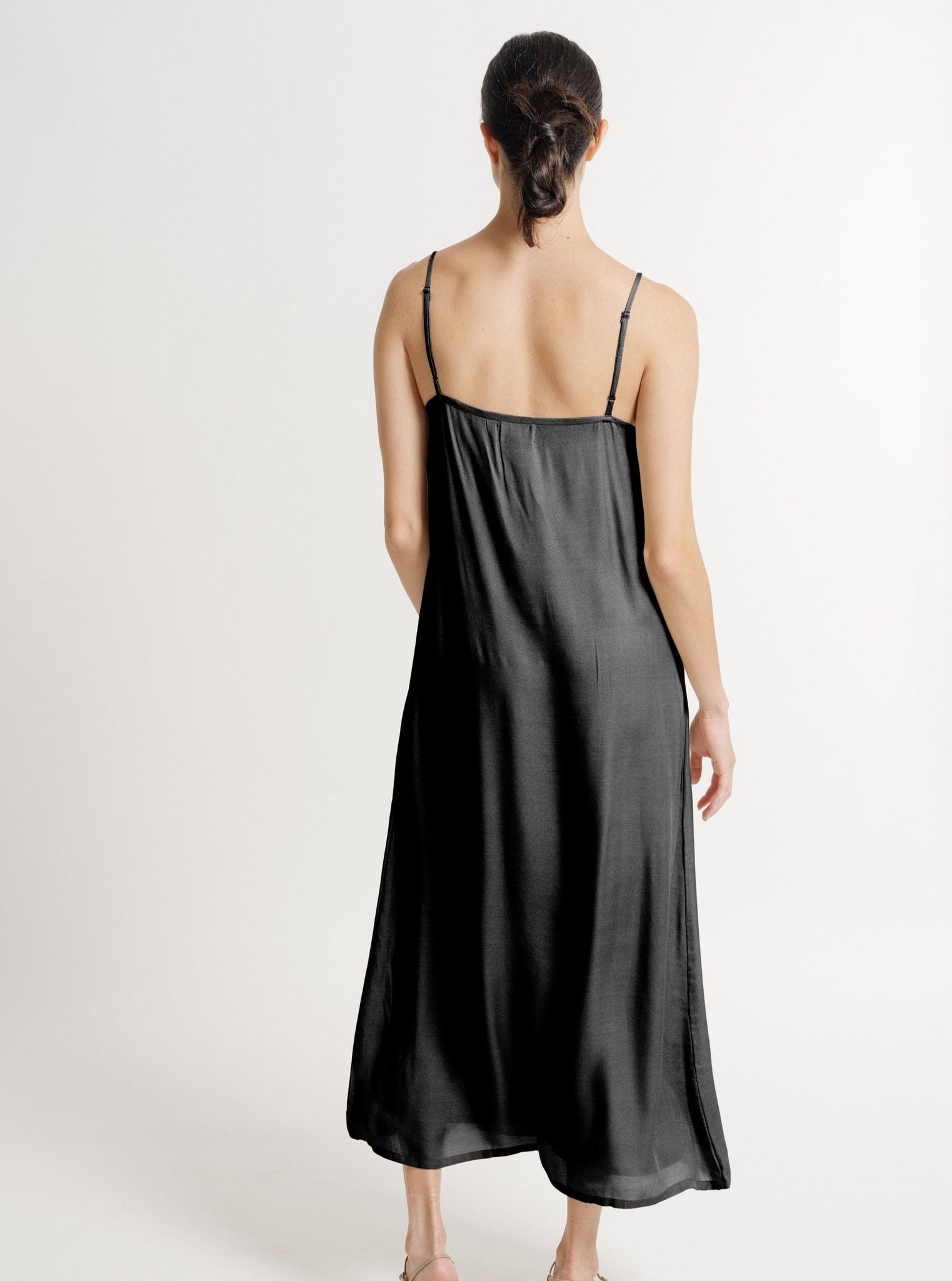 The sustainably made Kate Dress - Black in a maxi length showcases a beautifully flowing silhouette from the back view.