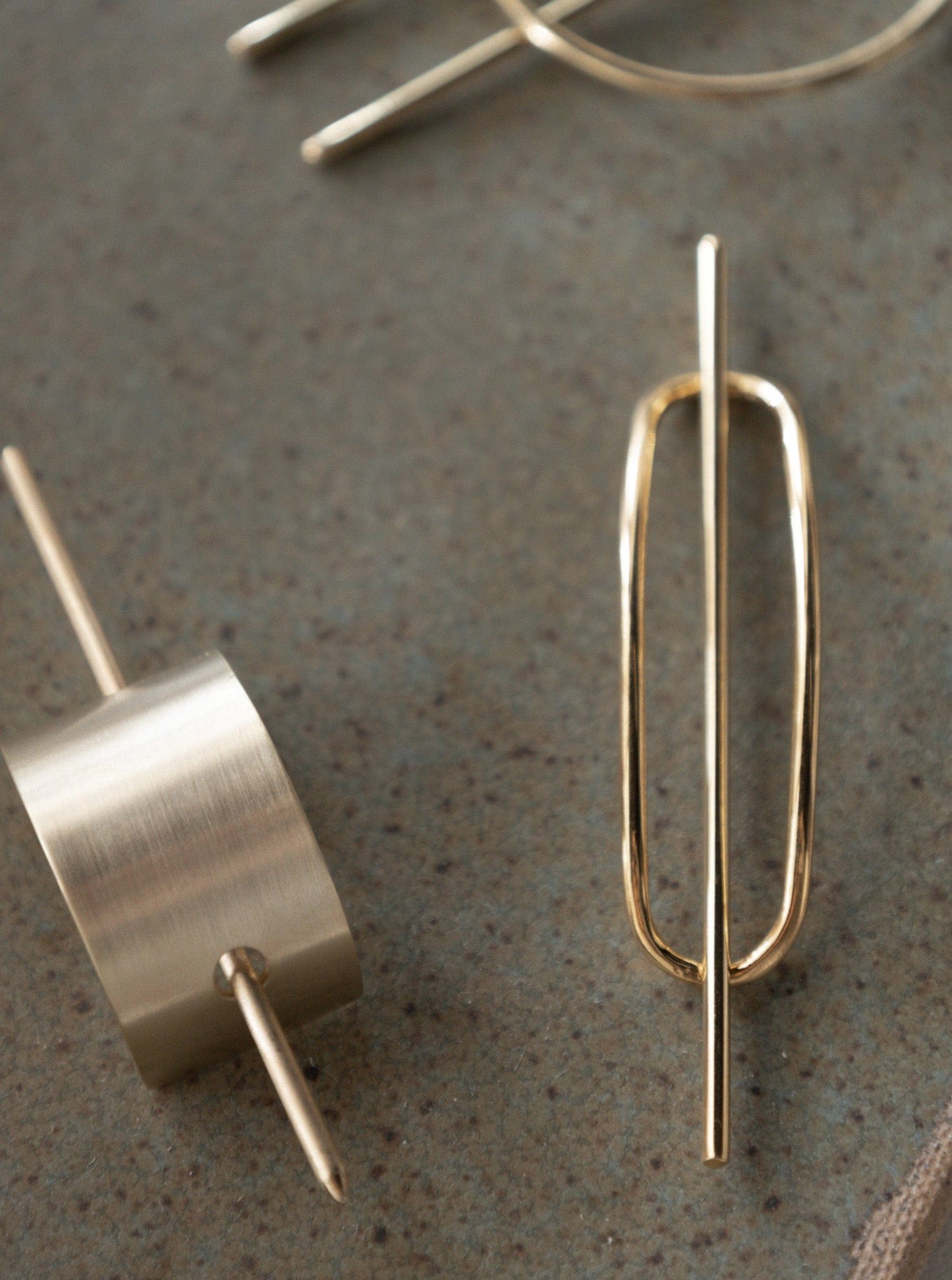 A pair of Petite Oval Hair Pin - pre-order on a table.