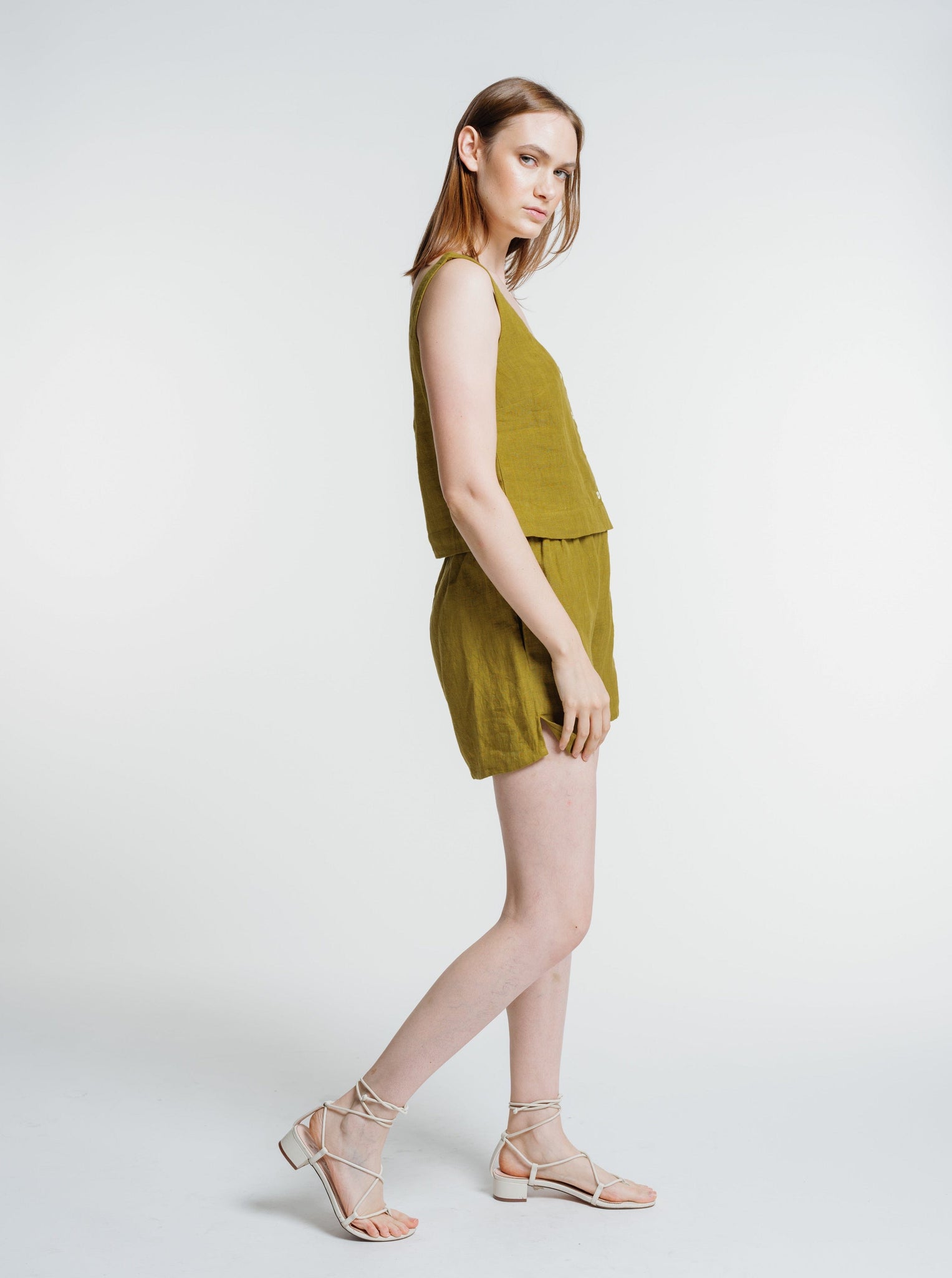 The model is wearing an Everyday Short - Dried Tobacco with an elastic waistband and sandals.