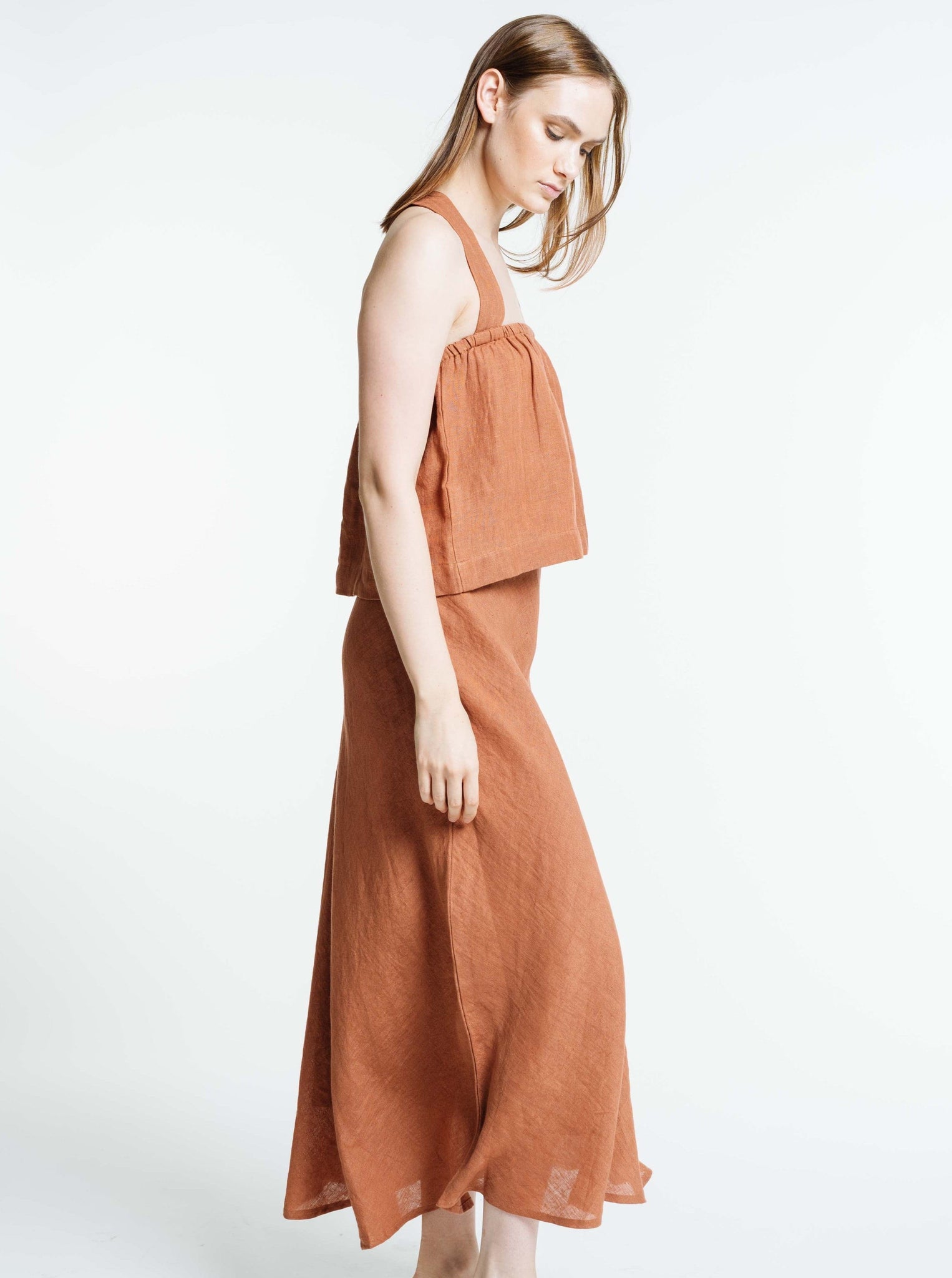 The model is wearing a Jardín Midi Skirt - Amber Brown - Sample.