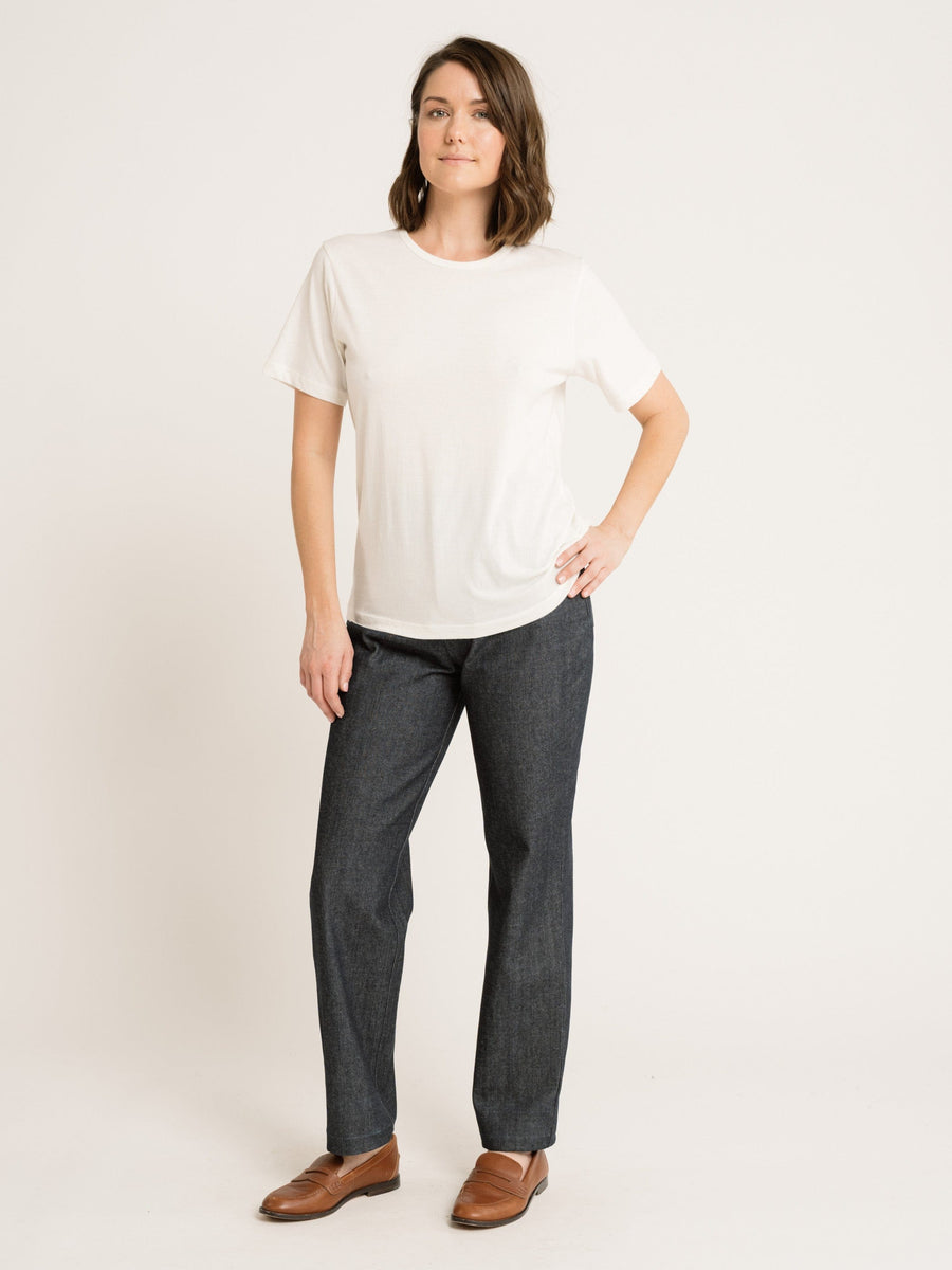 A woman wearing a Crewneck T-Shirt - Ivory - Sample and jeans.