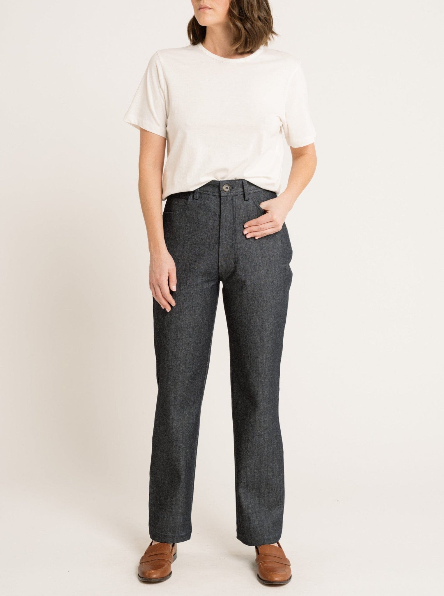 A woman wearing a white t-shirt made of organic cotton and Camp Pant - Vintage Denim - Sample.