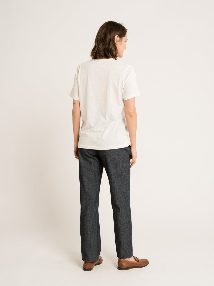 The back view of a woman wearing a handmade Ivory Crewneck T-Shirt and jeans.