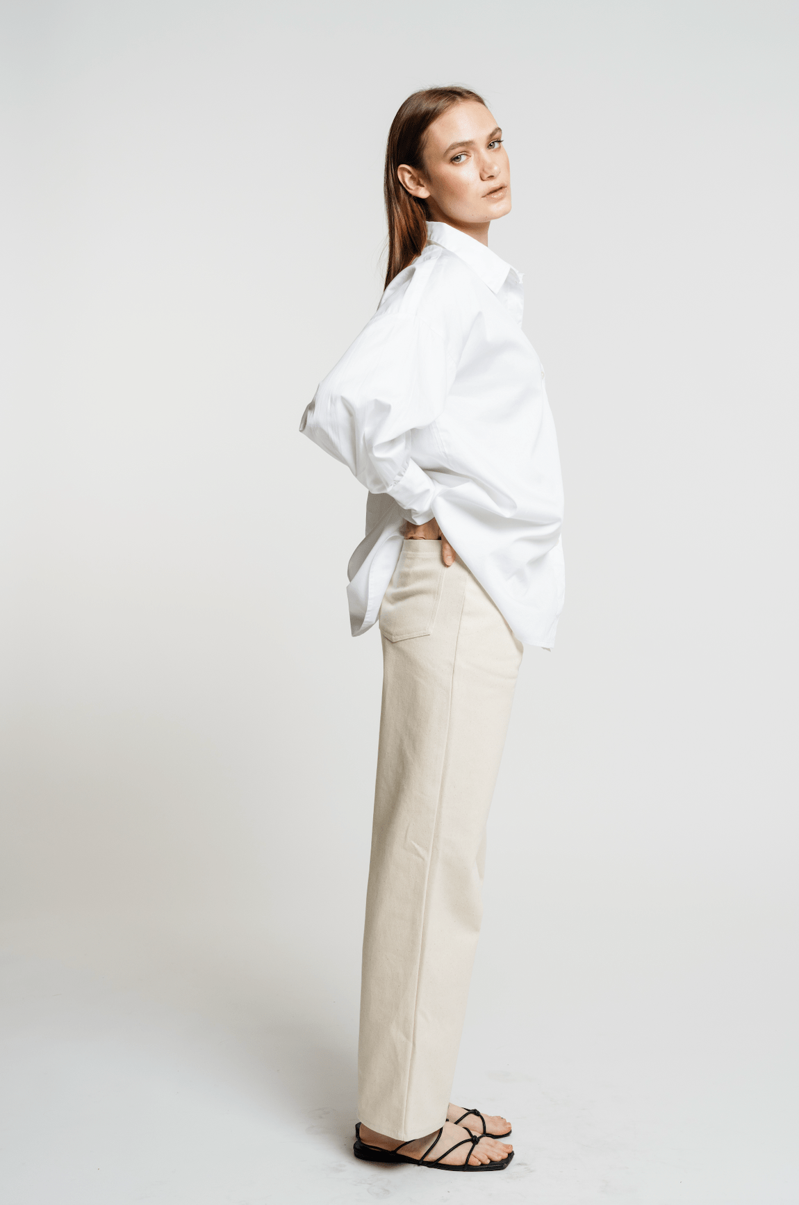 A model wearing the Museo Button Up - White shirt and beige pants.