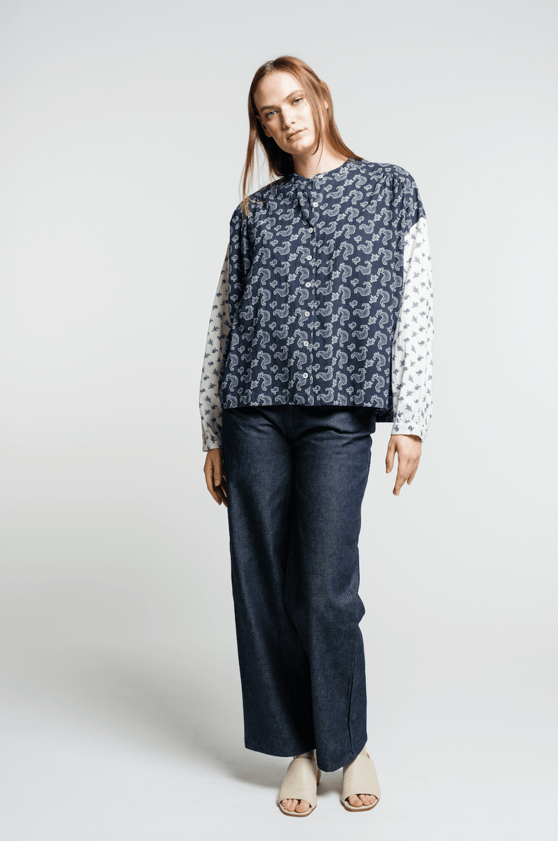 The model is wearing a blue polka dot Francoise Top - Indigo Paisley Block and wide leg pants in a 70s style.