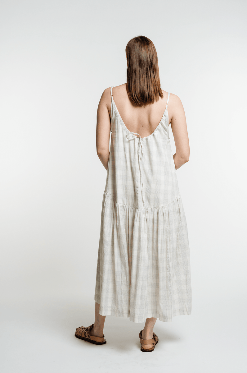 The back view of a woman wearing the Portrait Dress - Rivera Plaid.
