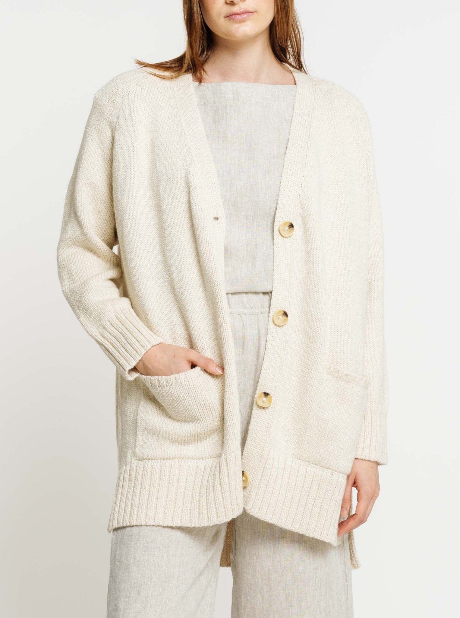 The model is wearing a Valley Cardigan - Vanilla with buttons.