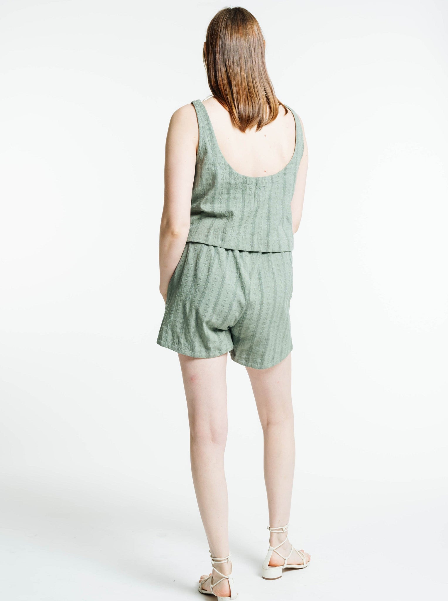 The back view of a woman wearing a Market Tank - Azure Broderie, creating a monochromatic look.