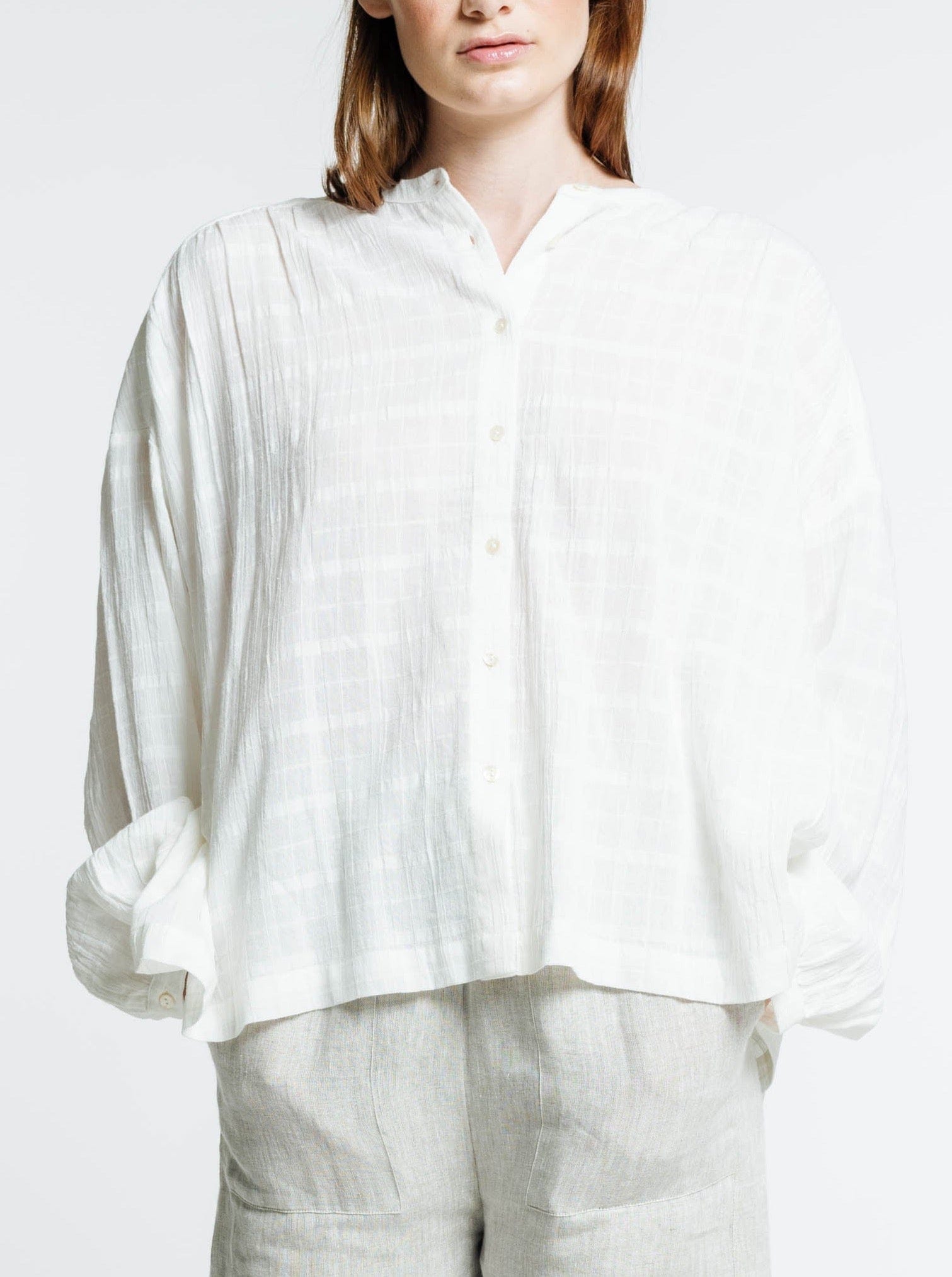 The model is wearing the Francoise Top - Alabaster Plaid and linen pants.