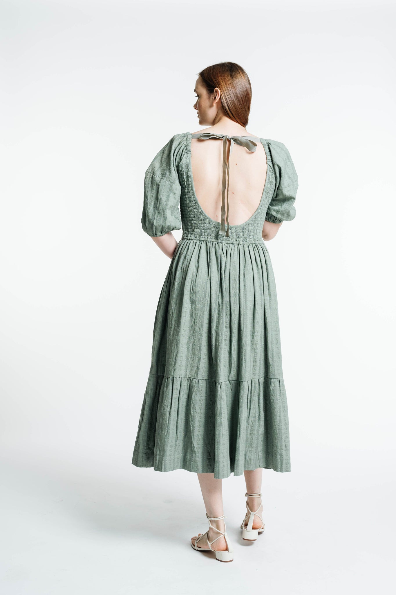 The back view of a woman wearing the Frida Midi Dress - Azure Broderie.