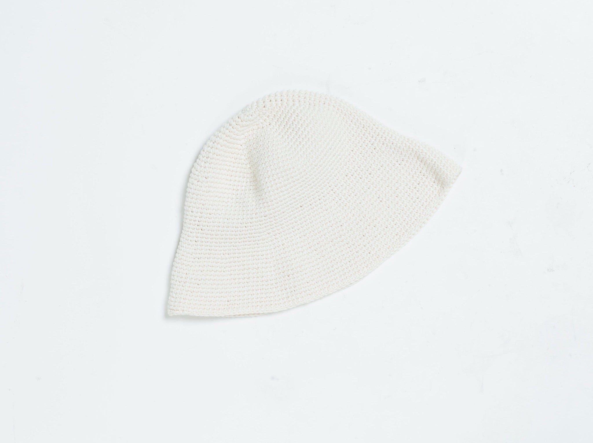 A vintage-inspired Crochet Bell Hat - Ivory on a white surface.