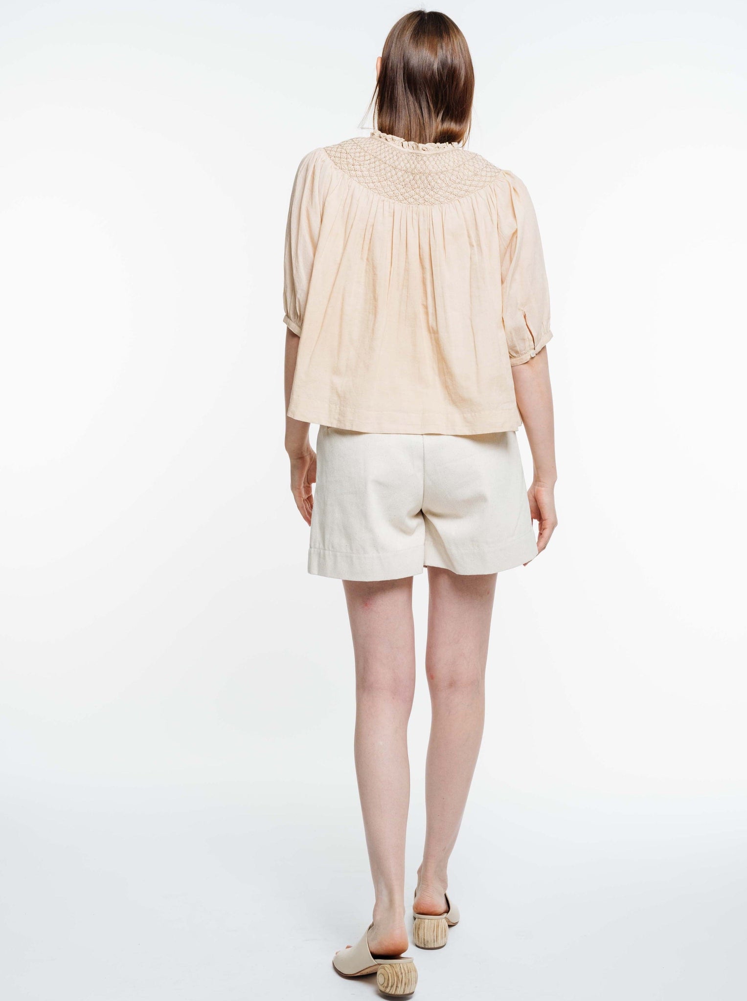 The back view of a woman wearing an organic cotton Lena Top - Acacia Wood.