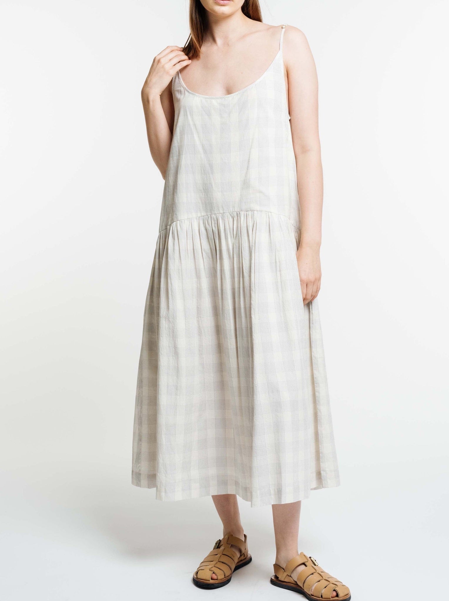 The model is wearing a white and beige Portrait Dress - Rivera Plaid.