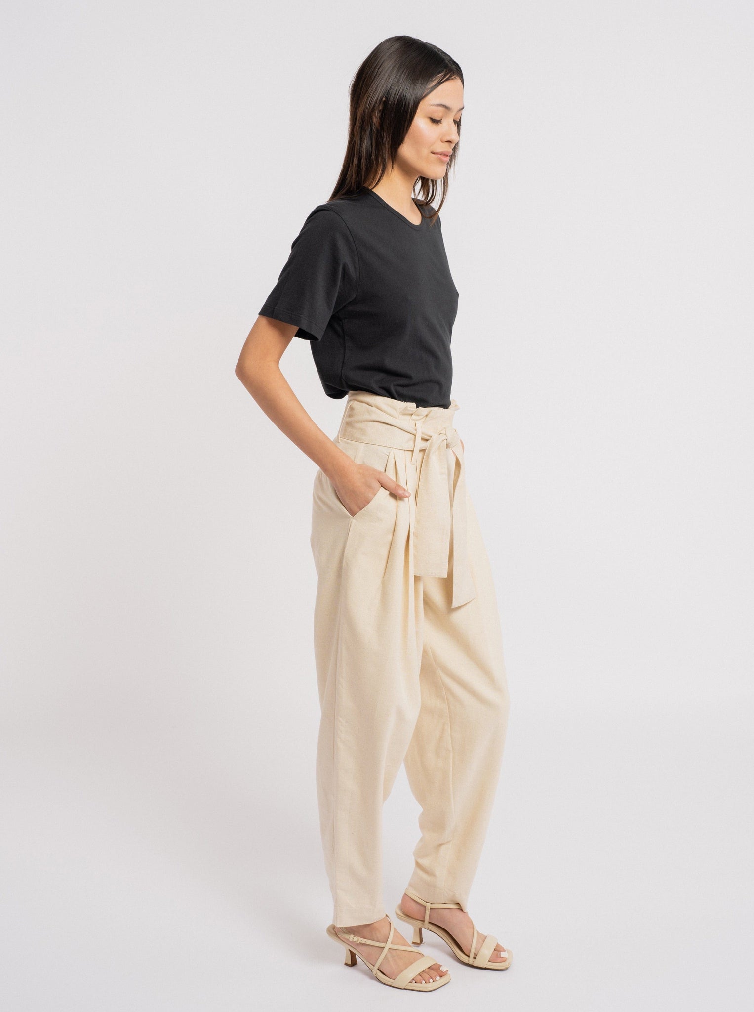 The model is wearing a black t-shirt and Traveler Pant - Ecru Silk Noil - Sample.