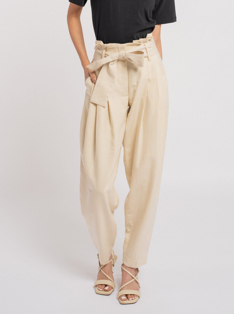 The model is wearing Traveler Pants in Ecru Silk Noil and a black t-shirt.